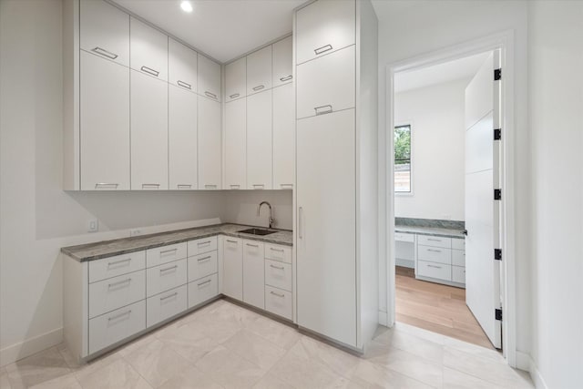 kitchen featuring white cabinetry and sink