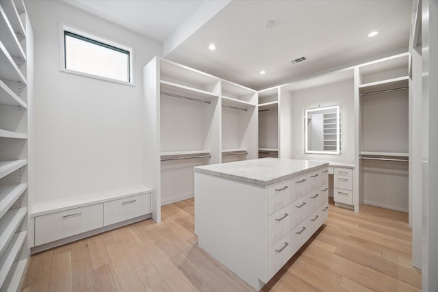 walk in closet with light hardwood / wood-style floors