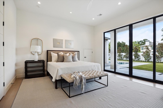 bedroom featuring access to exterior and light wood-type flooring