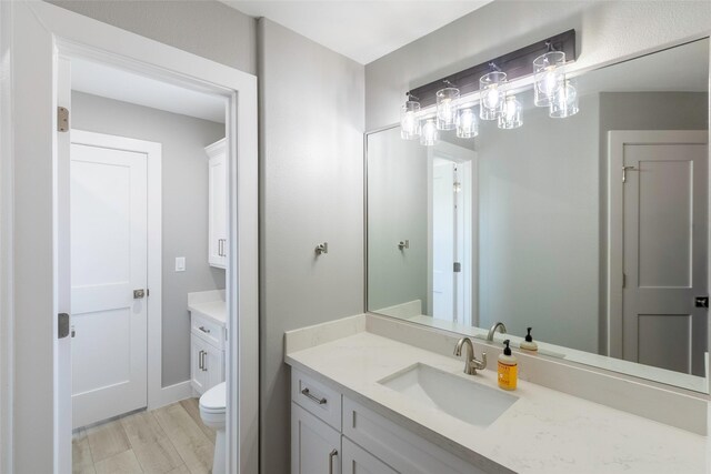 bathroom featuring hardwood / wood-style floors, toilet, and large vanity