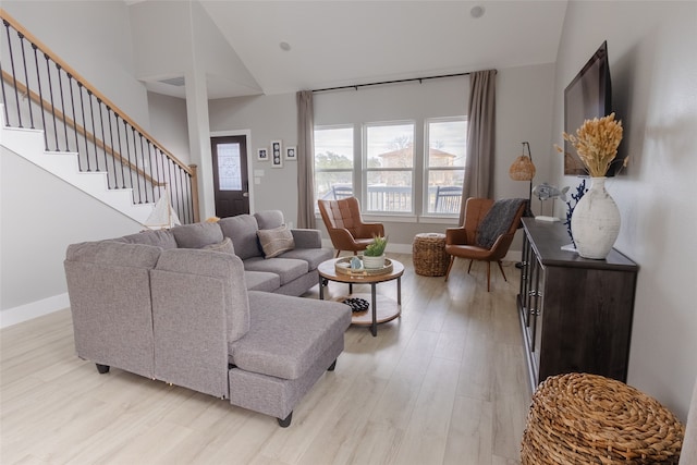 living room with high vaulted ceiling and light hardwood / wood-style floors