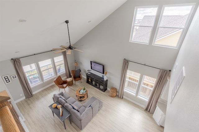 living room with high vaulted ceiling, ceiling fan, and light hardwood / wood-style floors