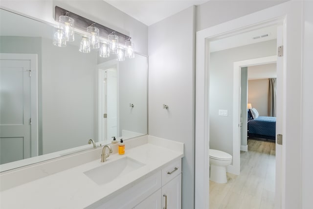 bathroom featuring wood-type flooring, vanity, and toilet