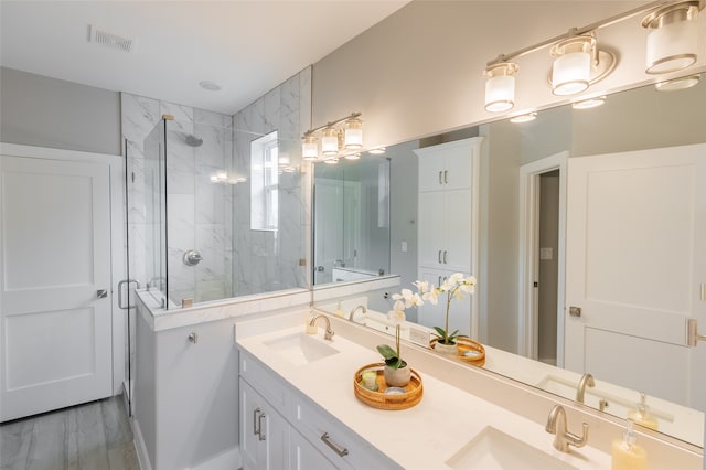 bathroom featuring a shower with shower door, double vanity, and hardwood / wood-style flooring