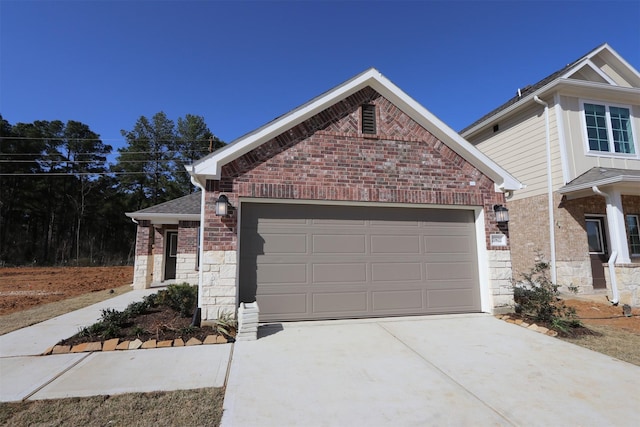 view of front facade featuring brick siding, roof with shingles, a garage, stone siding, and driveway