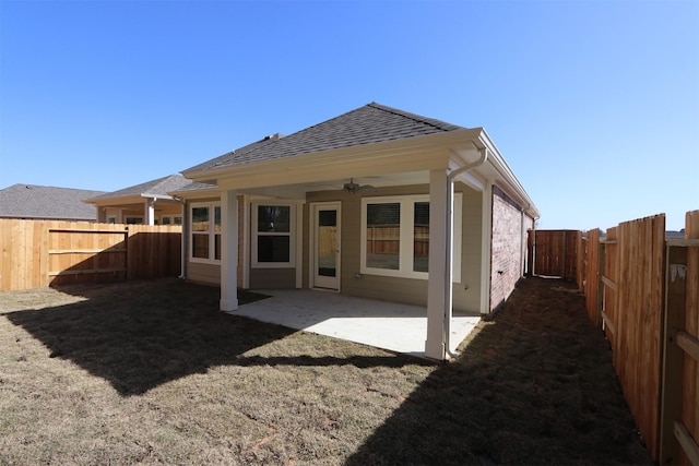 back of property featuring a fenced backyard, ceiling fan, a shingled roof, and a patio