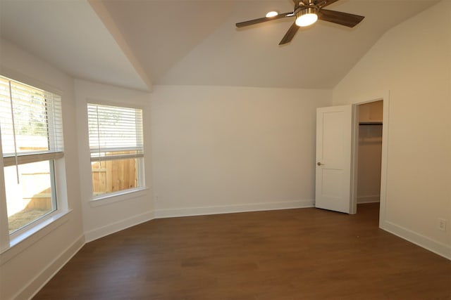 spare room featuring vaulted ceiling, wood finished floors, a ceiling fan, and baseboards