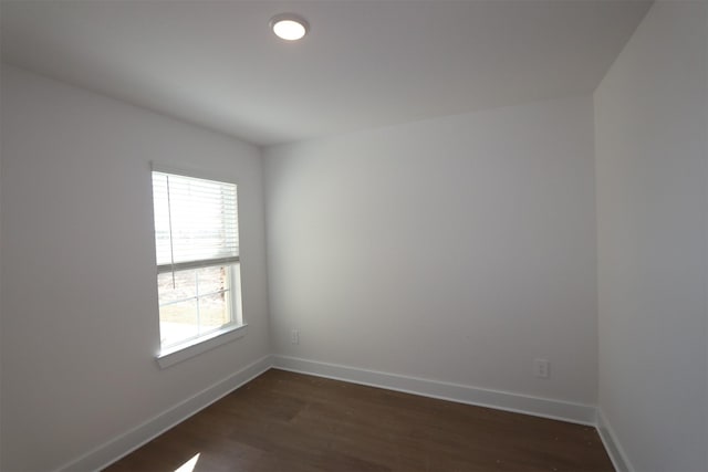 spare room with dark wood finished floors and baseboards