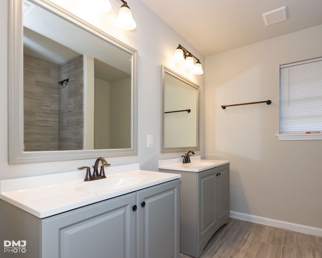 bathroom featuring tiled shower and vanity