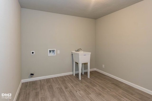 laundry room featuring hookup for an electric dryer, hookup for a washing machine, and light hardwood / wood-style floors