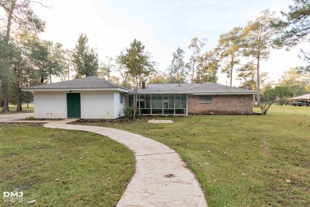 back of property featuring a sunroom and a lawn