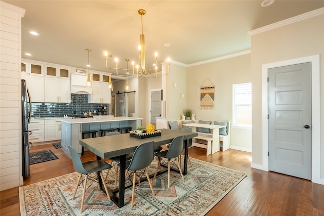 dining room with a chandelier, hardwood / wood-style floors, and crown molding