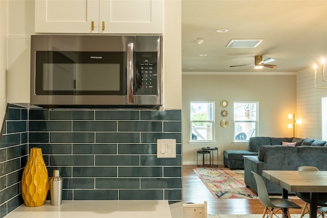 bathroom featuring backsplash, ceiling fan, wood-type flooring, and ornamental molding