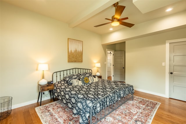 bedroom with beamed ceiling, hardwood / wood-style floors, and ceiling fan