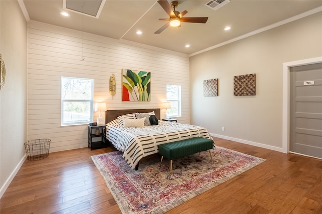 bedroom with hardwood / wood-style floors, ceiling fan, and multiple windows