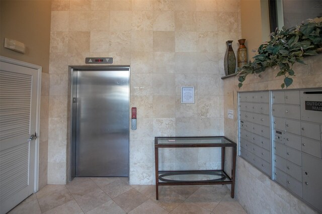 bathroom with tile flooring, mail boxes, and elevator