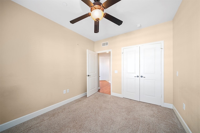 unfurnished bedroom with carpet, a closet, and ceiling fan