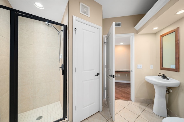 bathroom with tile floors, a shower with door, and toilet