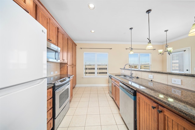 kitchen featuring appliances with stainless steel finishes, sink, tasteful backsplash, and hanging light fixtures