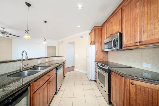 kitchen featuring stainless steel appliances, dark stone counters, sink, tasteful backsplash, and ceiling fan