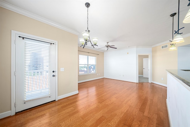 unfurnished dining area with ornamental molding, light wood-type flooring, and ceiling fan with notable chandelier