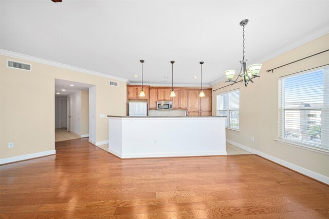 kitchen with an inviting chandelier, white fridge, light hardwood / wood-style flooring, and pendant lighting