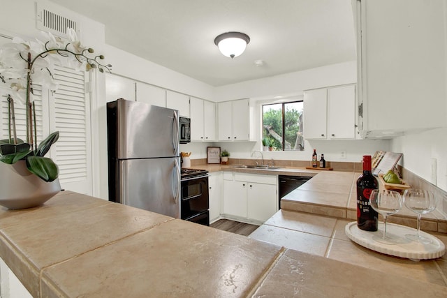 kitchen featuring white cabinetry, sink, and black appliances