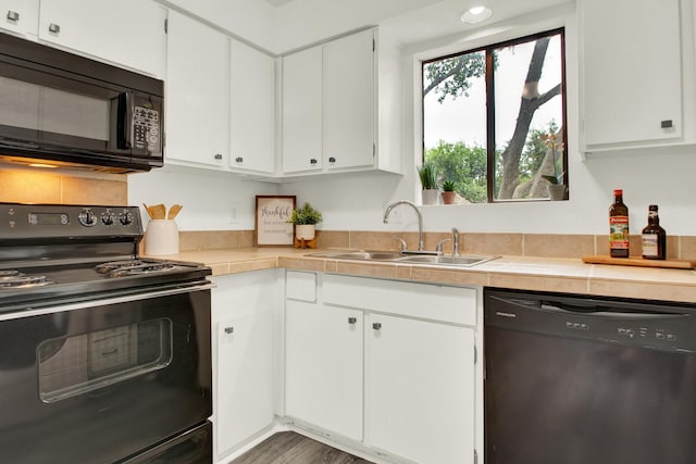 kitchen featuring black appliances, white cabinetry, sink, and tile countertops