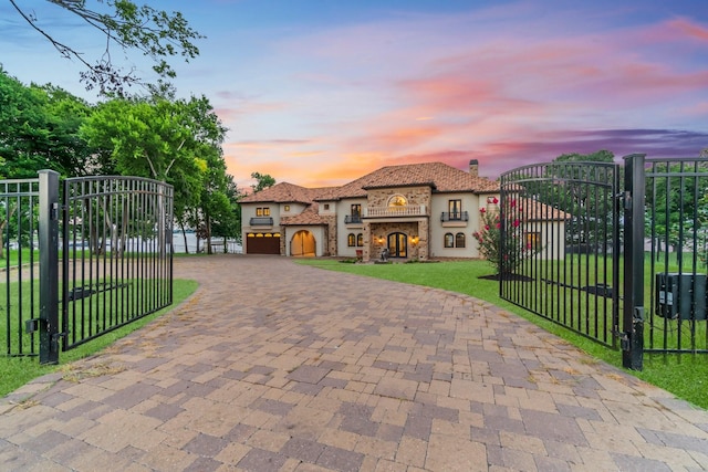 gate at dusk featuring a lawn