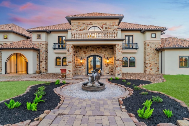 mediterranean / spanish-style house featuring french doors and a balcony