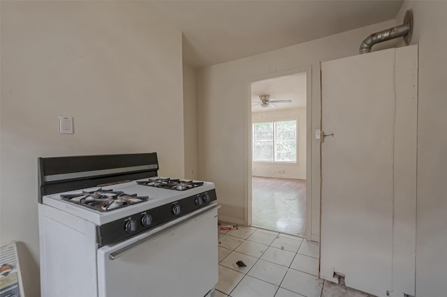 kitchen featuring white cabinets, ceiling fan, white gas stove, and light tile patterned flooring