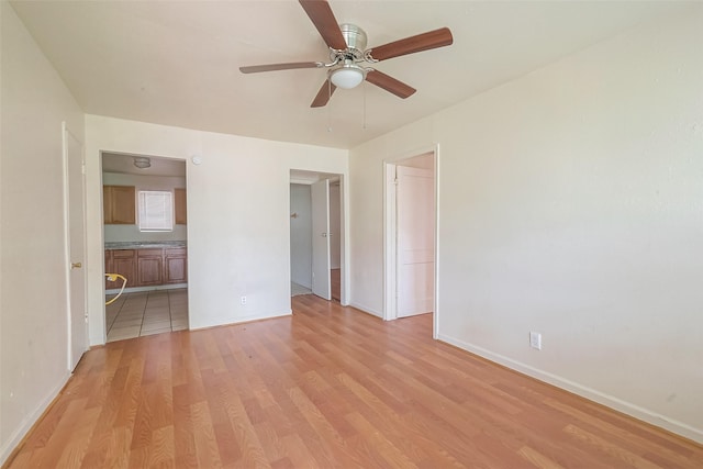 unfurnished bedroom featuring ensuite bathroom, ceiling fan, and light hardwood / wood-style flooring