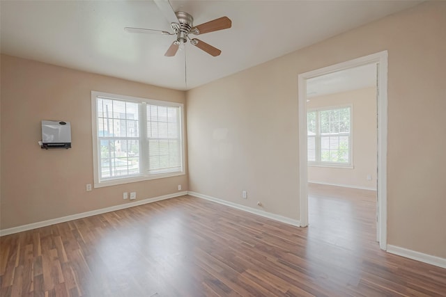 empty room with wood-type flooring, plenty of natural light, and ceiling fan