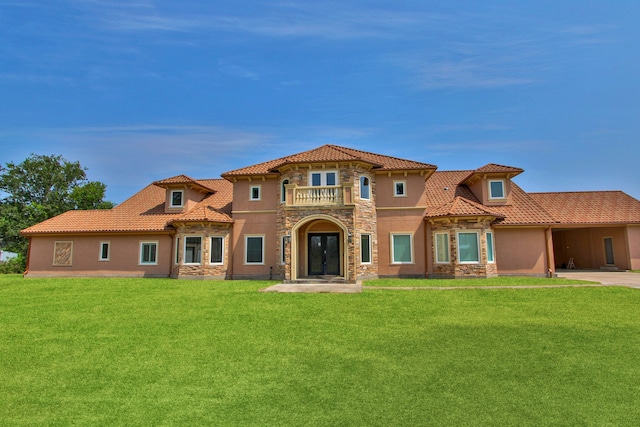 mediterranean / spanish home featuring a balcony and a front lawn