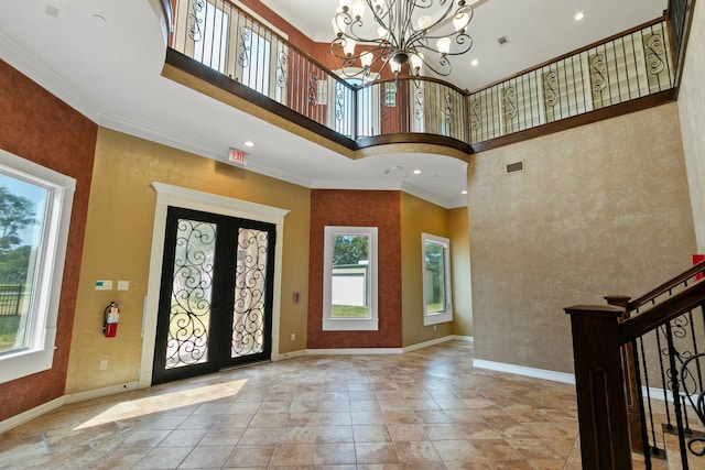 entryway featuring a towering ceiling, light tile patterned flooring, plenty of natural light, and an inviting chandelier