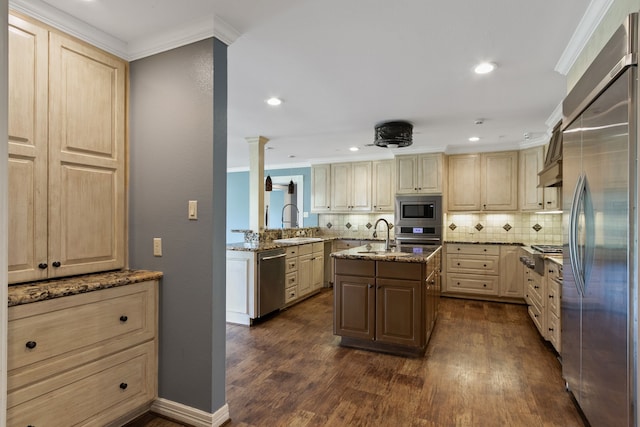 kitchen featuring dark wood-type flooring, a center island with sink, built in appliances, backsplash, and ornamental molding