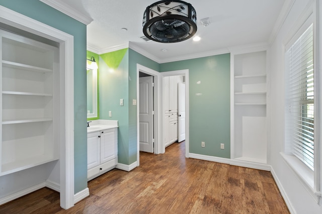 bathroom featuring vanity, built in shelves, ornamental molding, and hardwood / wood-style floors