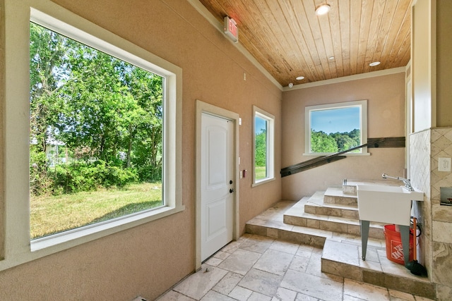 entryway with light tile patterned floors, ornamental molding, and wood ceiling