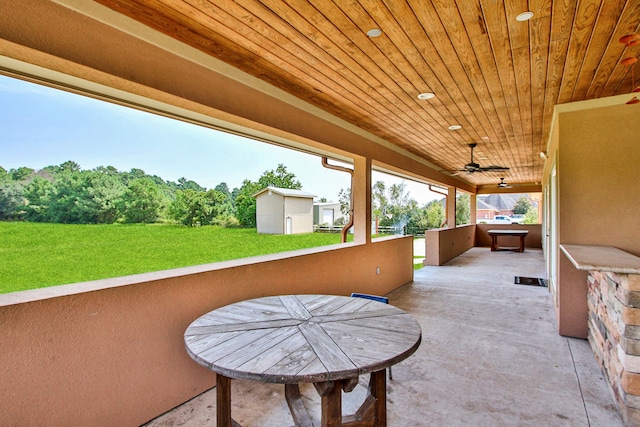 view of patio featuring ceiling fan and a storage shed