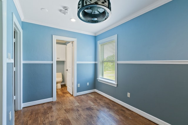 unfurnished bedroom with connected bathroom, ornamental molding, and hardwood / wood-style flooring