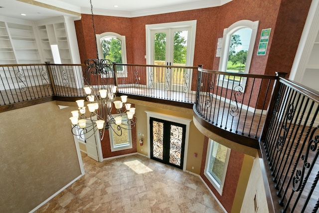 foyer featuring a notable chandelier, light tile patterned flooring, french doors, and ornamental molding