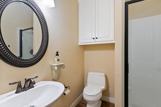 bathroom with wood-type flooring, sink, and toilet