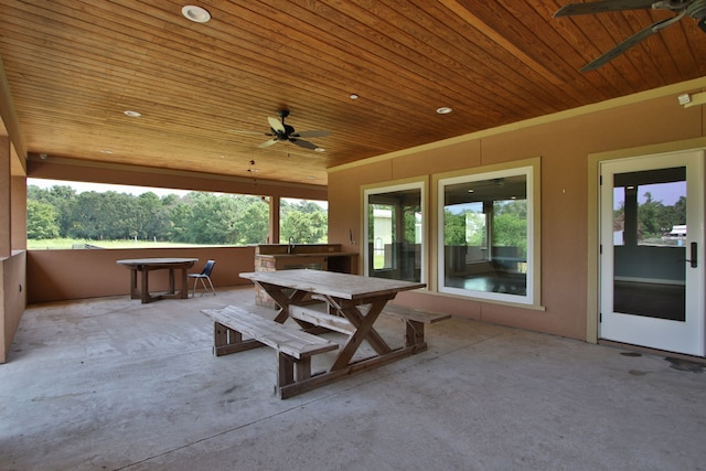 view of patio with ceiling fan and a hot tub