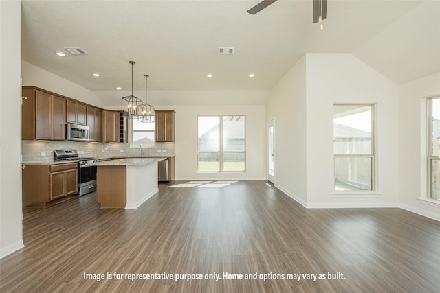 kitchen with a center island, hanging light fixtures, dark hardwood / wood-style floors, lofted ceiling, and appliances with stainless steel finishes