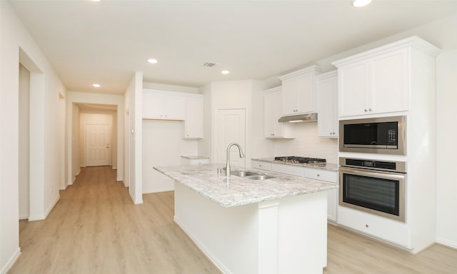 kitchen with a kitchen island with sink, sink, white cabinets, and appliances with stainless steel finishes