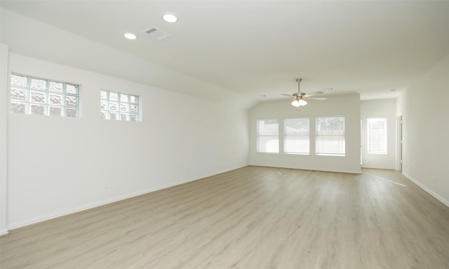 empty room with ceiling fan, lofted ceiling, and light wood-type flooring