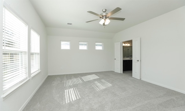 spare room with ceiling fan, light colored carpet, and vaulted ceiling