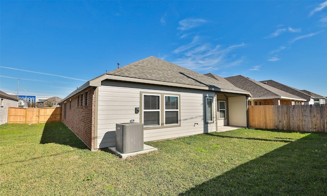 back of house with a lawn and cooling unit