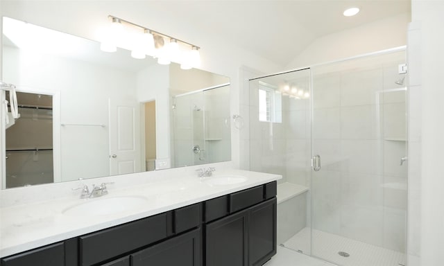 bathroom with vanity, a shower with shower door, and lofted ceiling