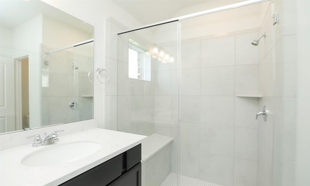 bathroom featuring a shower with door and vanity